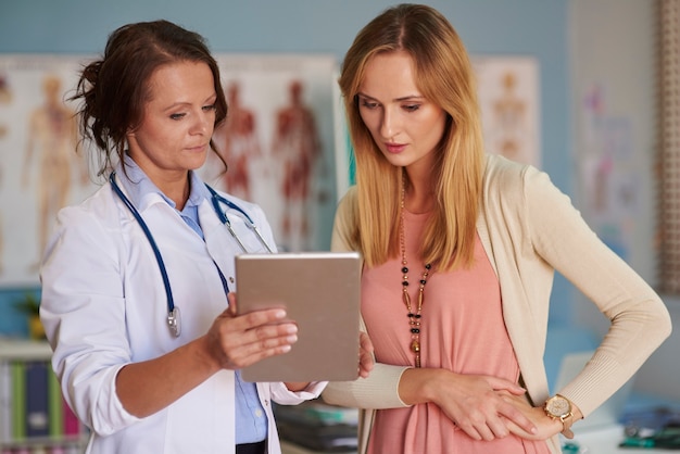 Foto gratuita médico que muestra los resultados del examen en la tableta digital