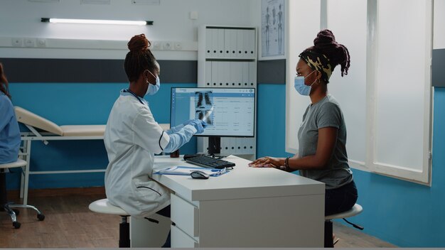 Médico con radiografía para examen con el paciente