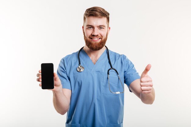 médico con teléfono mostrando el pulgar hacia arriba