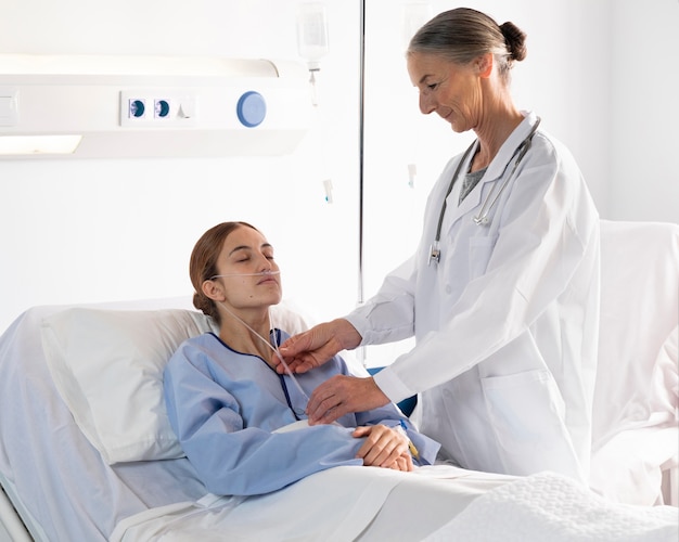 Médico de tiro medio ayudando al paciente