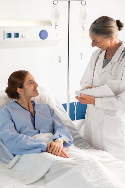 Médico de tiro medio discutiendo con el paciente