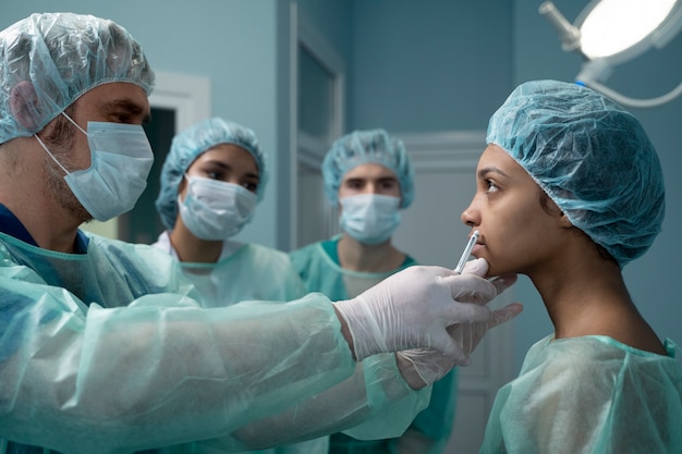 Médico de tiro medio con equipo revisando paciente