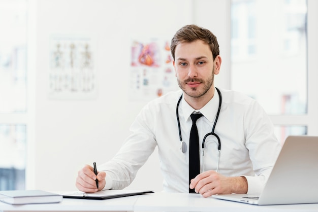 Médico de tiro medio escribiendo