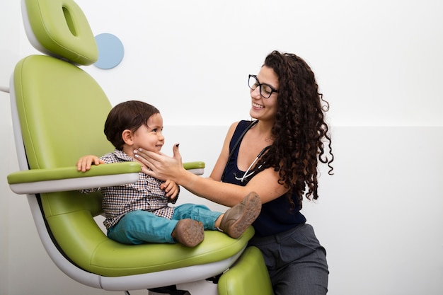 Foto gratuita médico de tiro medio examinando a un niño