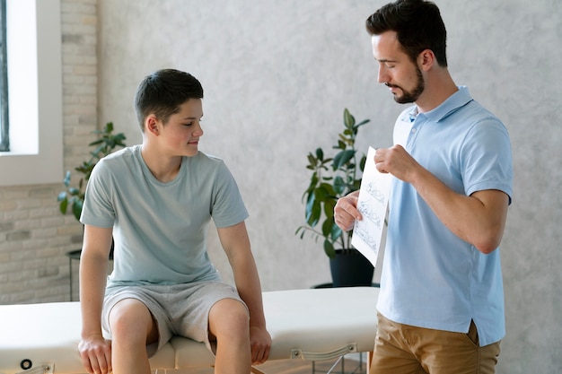 Médico de tiro medio explicando al niño