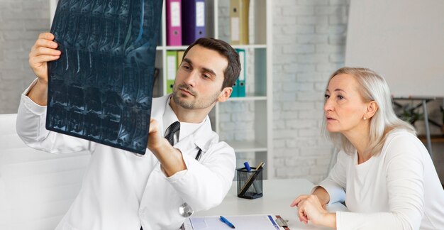 Foto gratuita médico de tiro medio explicando la radiografía