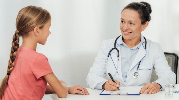 Médico de tiro medio hablando con el paciente