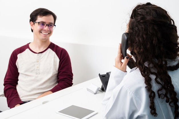 Médico de tiro medio hablando por teléfono.