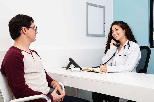 Médico de tiro medio hablando por teléfono.