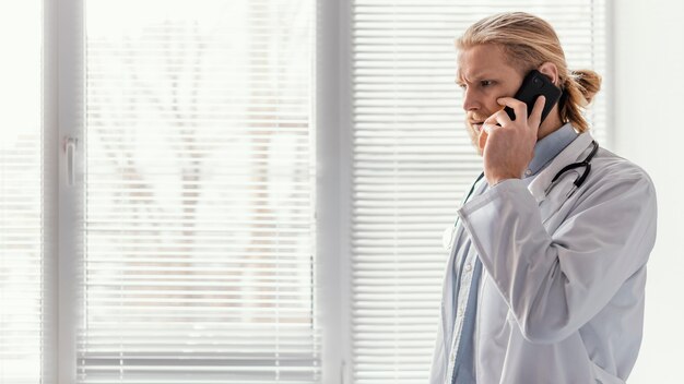 Médico de tiro medio hablando por teléfono