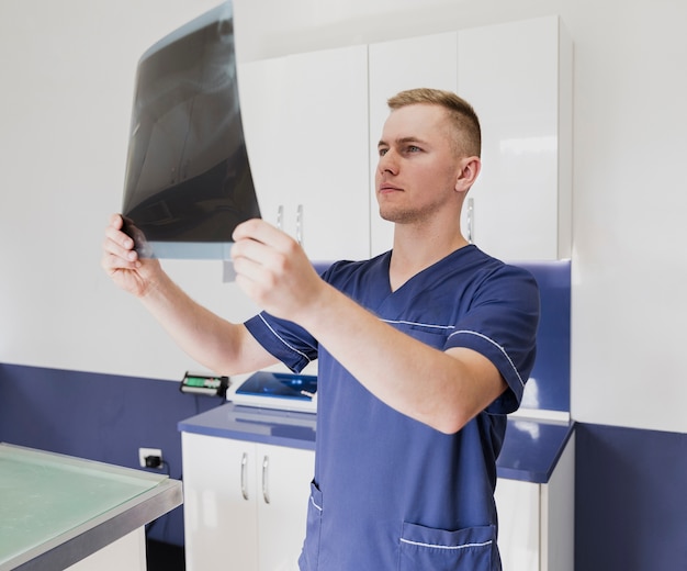 Médico de tiro medio leyendo radiografía