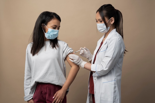 Médico de tiro medio y mujer con máscaras.