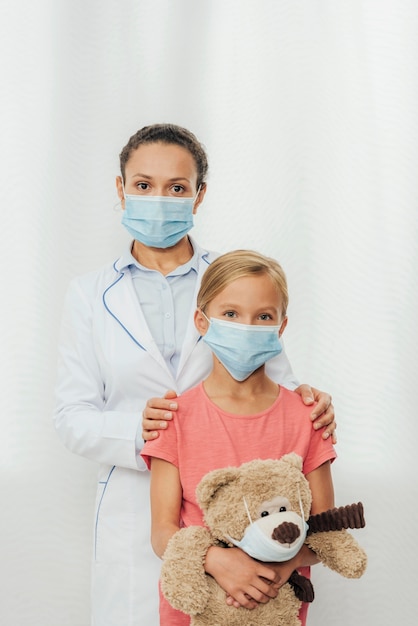 Médico de tiro medio y niño posando