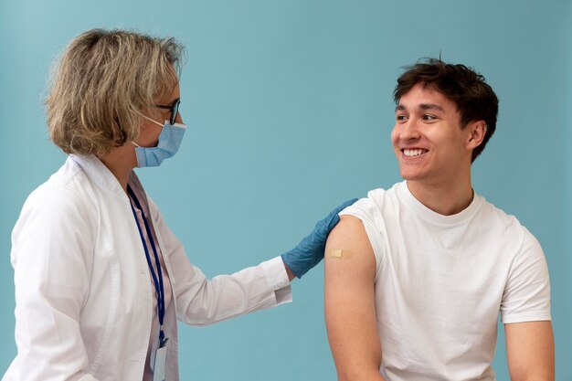 Médico de tiro medio y paciente sonriente