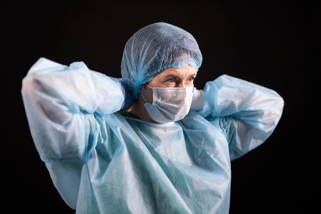 Médico de tiro medio poniéndose mascarilla