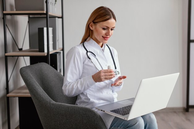 Médico de tiro medio sentado en una silla