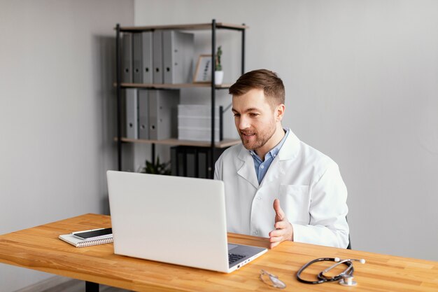 Médico de tiro medio trabajando en el escritorio