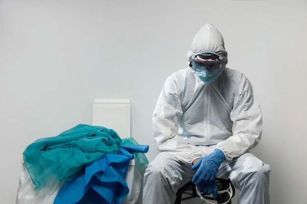 Foto gratuita médico de tiro medio vistiendo traje de materiales peligrosos