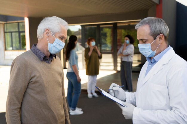 Médico de vacunación en el centro de llenado de información de pacientes en el bloc de notas