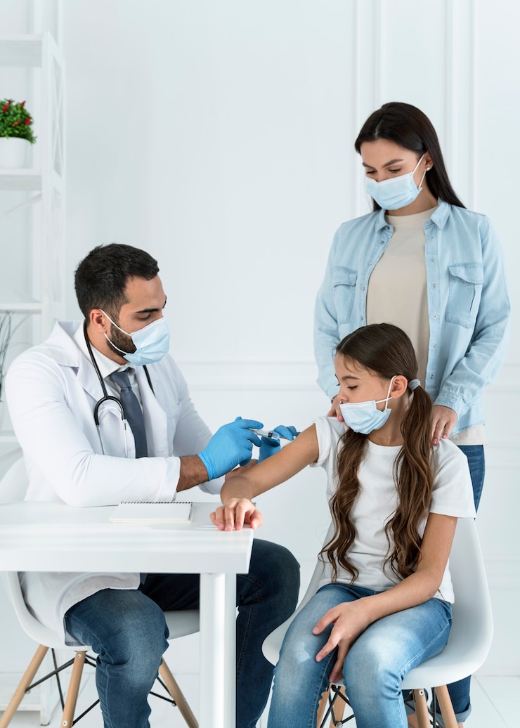 Foto gratuito médico vacunando a una niña que es apoyada por su madre