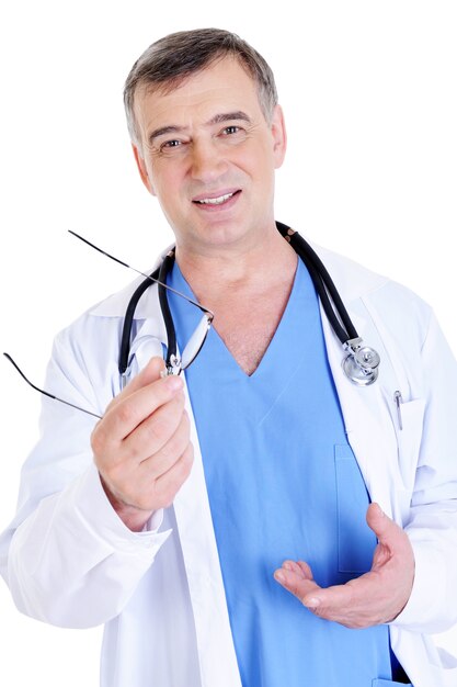 Médico varón exitoso sosteniendo sus anteojos - aislado en blanco