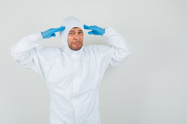 Médico varón señalando con el dedo a la cabeza en traje protector