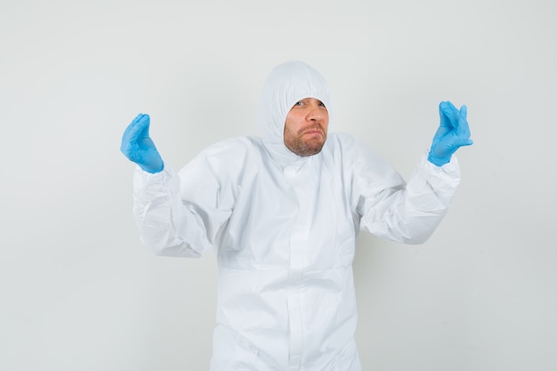 Médico varón en traje de protección, guantes haciendo gesto italiano