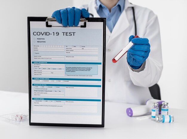 Médico de vista frontal con formulario de prueba covid