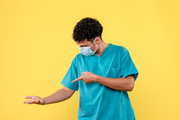 Médico de vista frontal, el médico de la máscara está hablando de qué hacer si le duele la mano