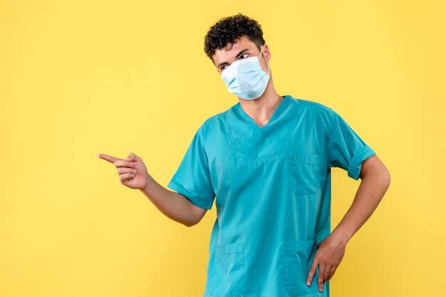 Médico de vista frontal el médico con máscara hace recomendaciones a los pacientes con coronavirus