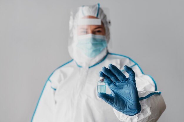 Médico de vista frontal sosteniendo una botella de vacuna