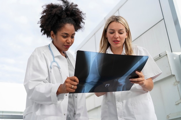 Foto gratuita médicos de ángulo bajo que miran la radiografía.