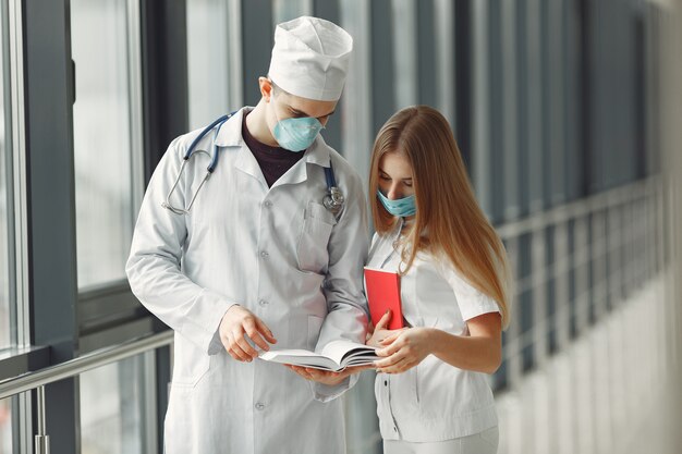 Los médicos con máscaras están discutiendo el problema en una sala.