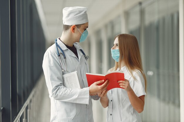 Los médicos con máscaras están discutiendo el problema en una sala.