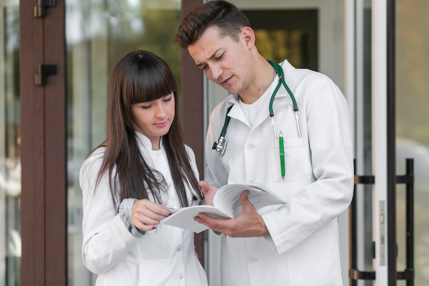 Médicos de pie y leyendo papeles en el hospital