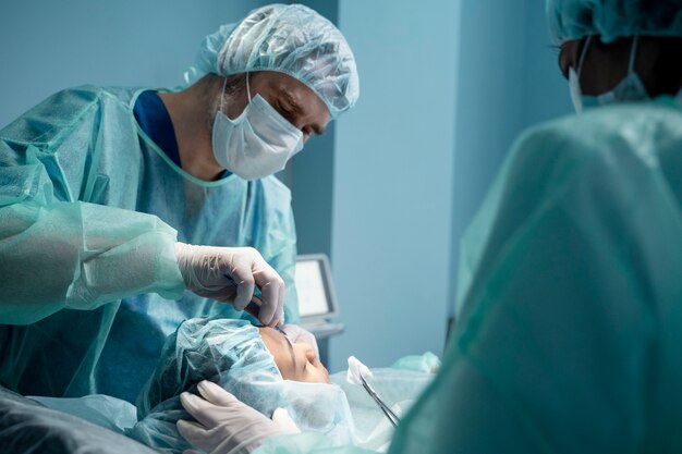 Médicos que realizan una rinoplastia en quirófano