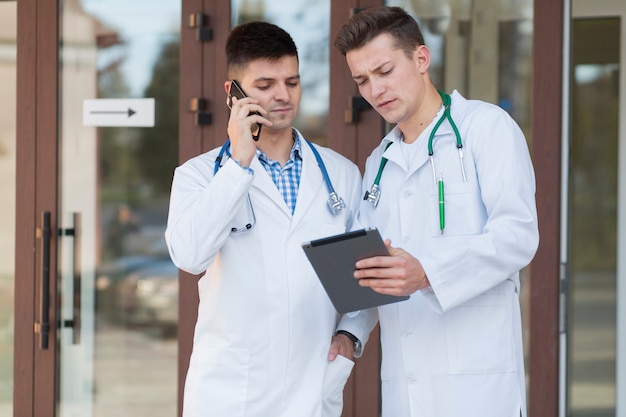 Médicos con tableta y teléfono inteligente