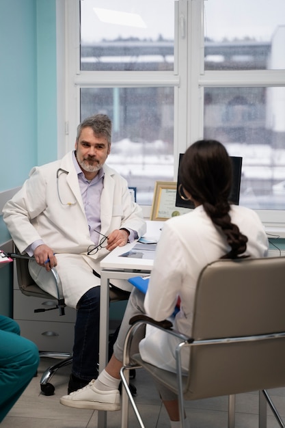 Médicos de tiro completo charlando en el trabajo.