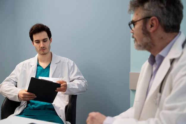 Médicos de tiro medio charlando en el trabajo.