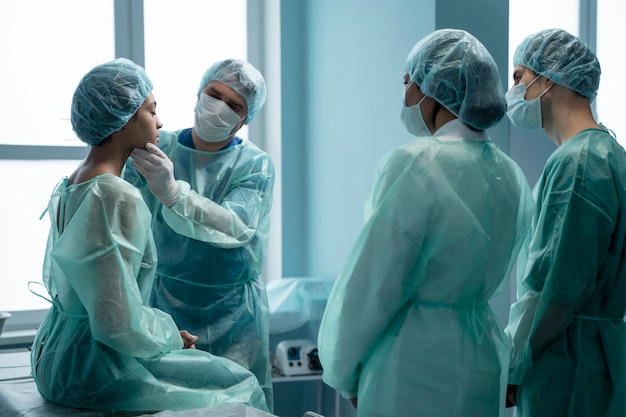 Médicos de tiro medio revisando al paciente