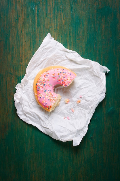 Foto gratuita medio donut rosa sobre una servilleta