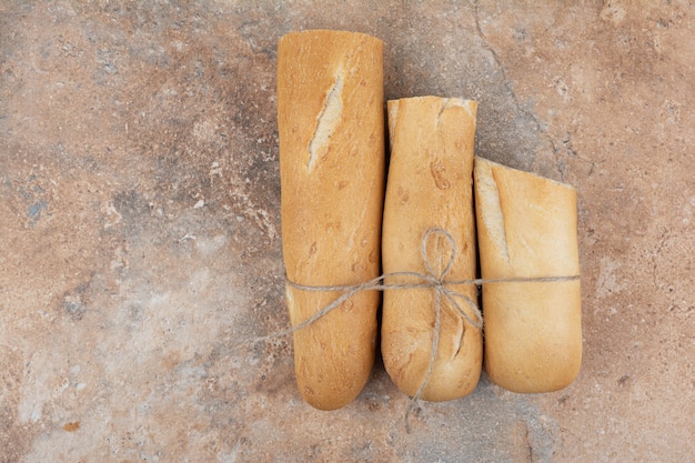 Medio pan baguette cortado sobre fondo de mármol