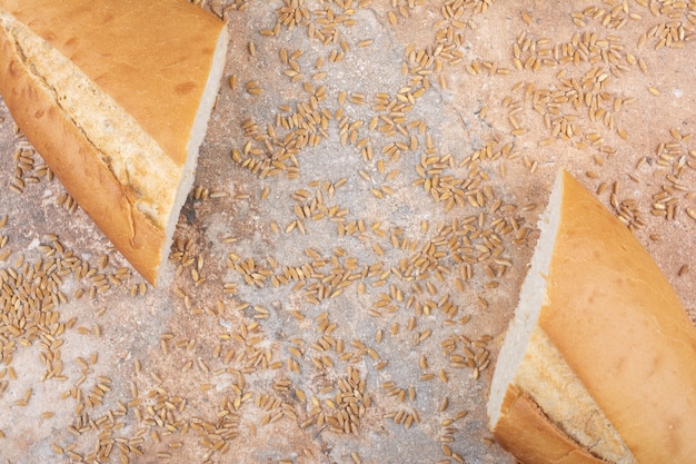 Medio pan de trigo cortado con cebada sobre superficie de mármol