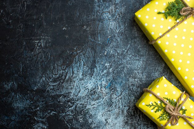 Medio plano de fondo de Navidad con cajas de regalo amarillas para miembros de la familia sobre fondo oscuro