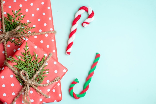 Foto gratuita medio plano de fondo de navidad con cajas de regalo y caramelos sobre fondo verde pastel