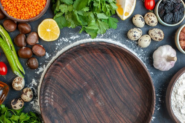 Medio tiro de comida cocinando con huevos paquetes verdes limón ajo limón y olla marrón vacía en azul