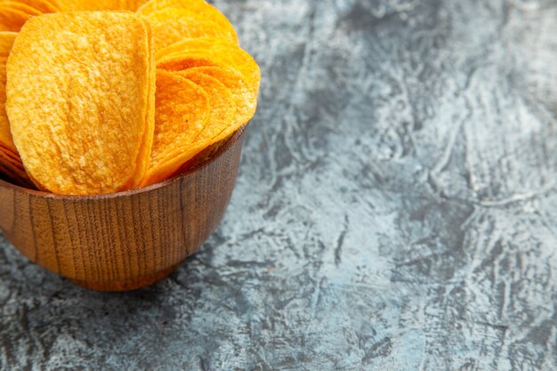 Medio tiro de deliciosas patatas fritas crujientes caseras en mesa gris