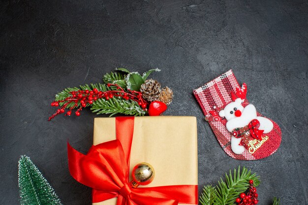 Medio tiro del estado de ánimo navideño con hermosos regalos con cinta en forma de arco y accesorios de decoración de ramas de abeto calcetín de Navidad sobre un fondo oscuro