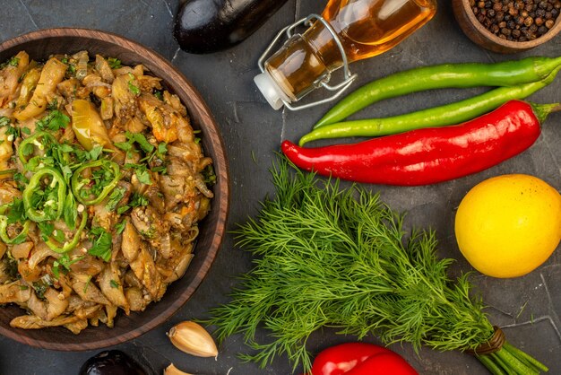 Medio tiro de harina de berenjena caída botella de aceite verduras frescas paquete verde pimienta sobre fondo de color oscuro