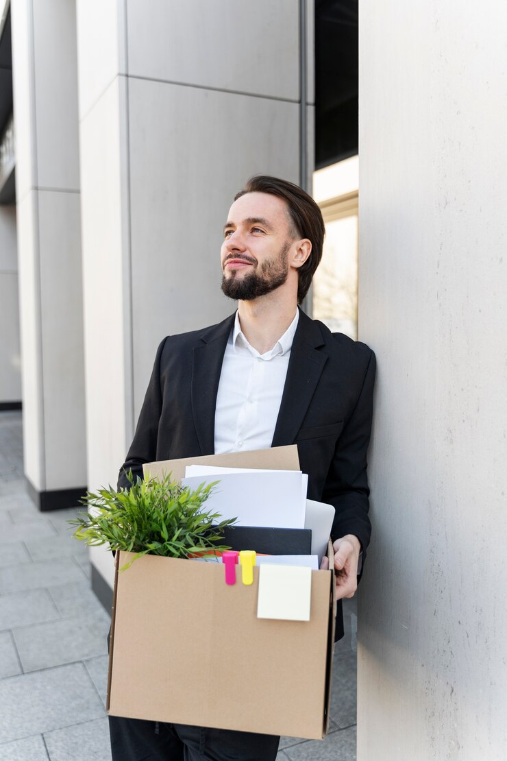 Photo Gratis medium shot man resigning with cardboard box